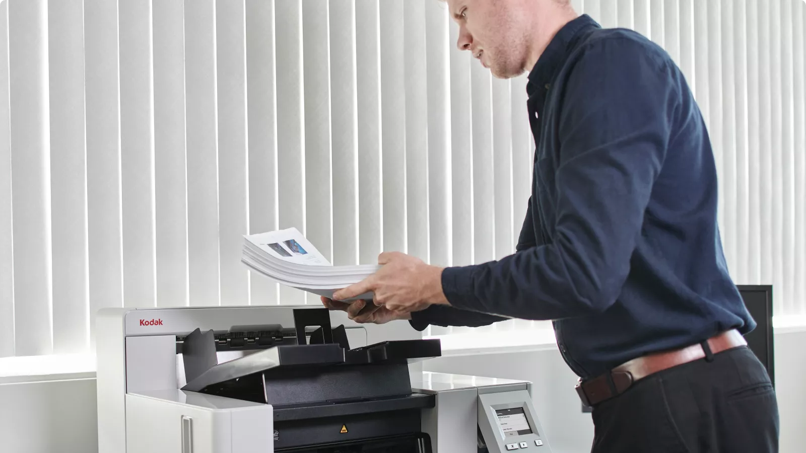 Man standing at a KODAK i5650 Scanner